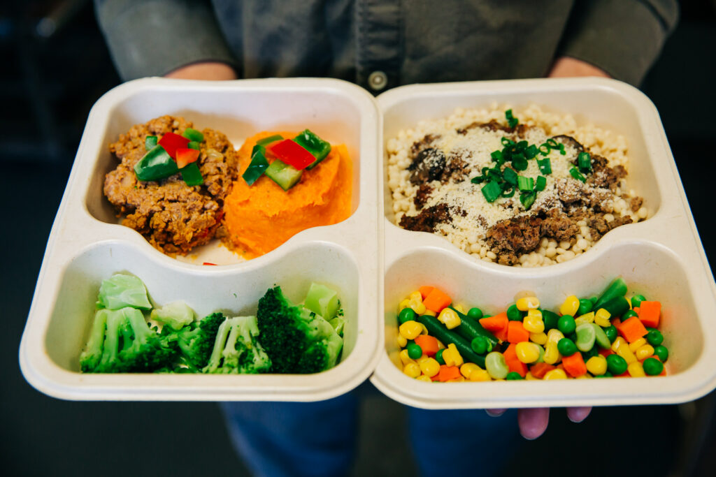 Hands holding meal trays